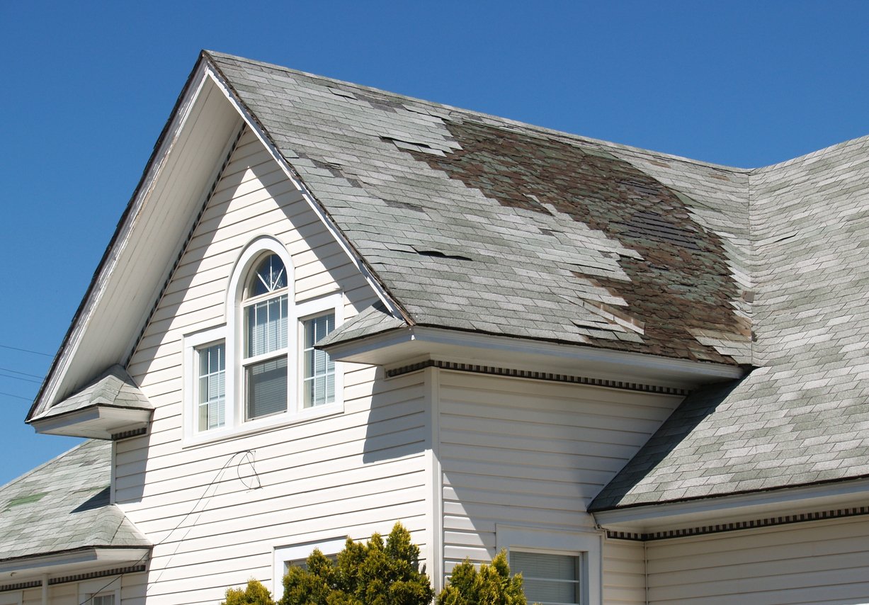 Chicago residential roof with missing tiles from wind damage.