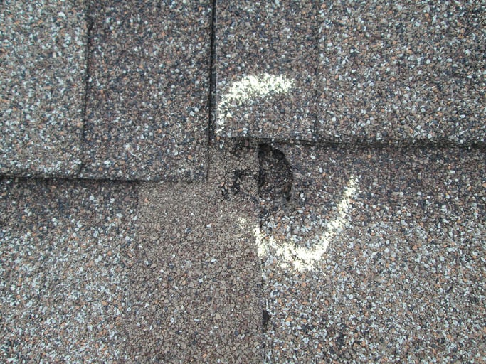 Close up of hail damage on a roof shingle.